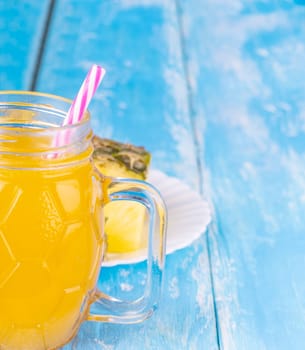 Pineapple and pineapple juice on the blue board background