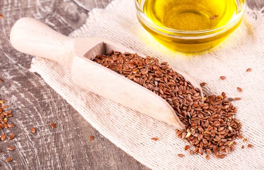 Brown flax seeds and flaxseed oil on a wooden surface