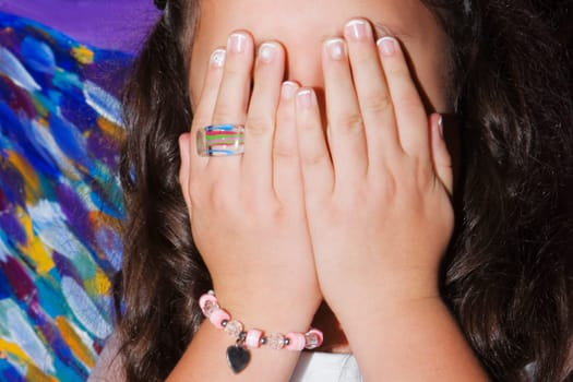 Close-up of a girl covering her face with her hands