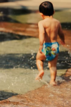 Rear view of a baby boy playing in water