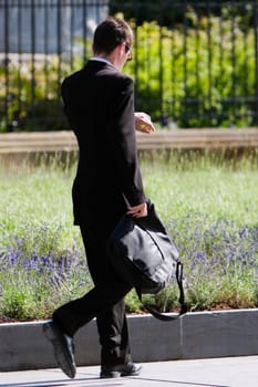 Side profile of a businessman holding a bag and walking