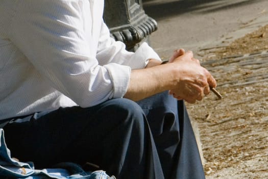 Mid section view of a man holding a cigarette