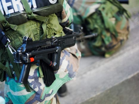Close-up of a machine gun on the back of an army soldier