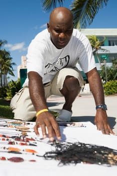 Mature man selling necklaces at the roadside