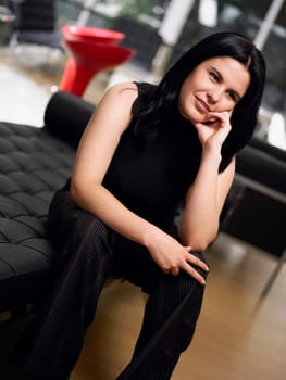 Close-up of a young woman sitting on a couch