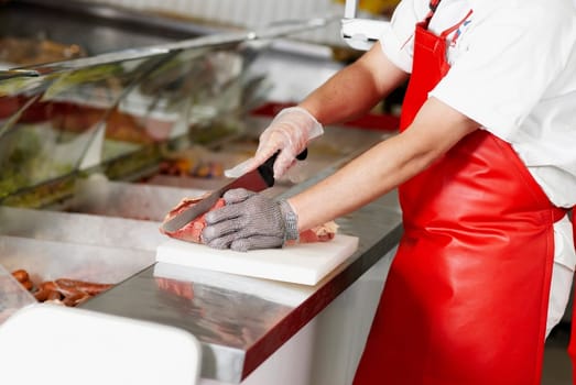 Close-up of a butcher cutting meat in a butcher shop