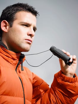 Close-up of a young man holding a pair of binoculars