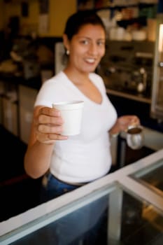 Portrait of a mid adult woman holding a disposable cup and smiling