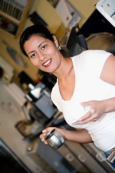 Portrait of a mid adult woman holding a coffee cup and a mug in a cafe