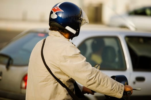 Rear view of a man riding a motor scooter