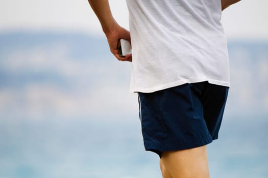 Mid section view of a man holding an MP3 player