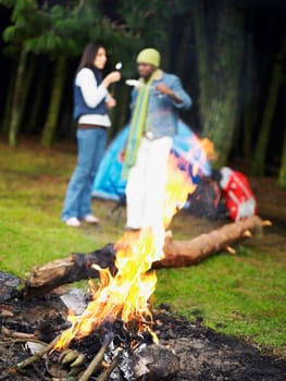 Young couple standing near a campfire