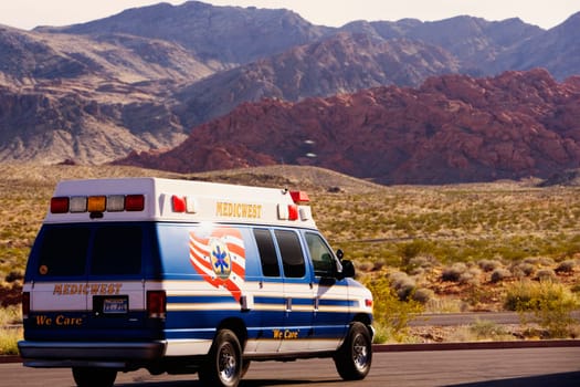 Ambulance on the road passing through an arid landscape, Las Vegas, Nevada, USA