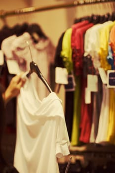 Close-up of a human hand holding clothes in a clothing store