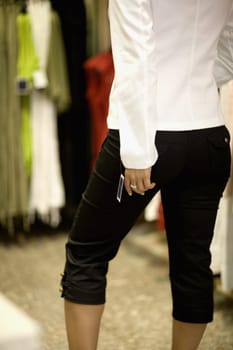 Mid section view of a mid adult woman standing in a clothing store, Barcelona, Spain