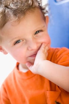Portrait of a boy with his hand over his mouth