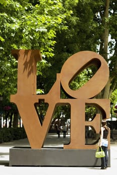 Rear view of a woman standing in front of a sculpture, Madrid, Spain