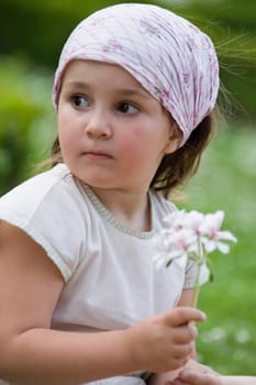 Close-up of a girl holding a flower and looking away