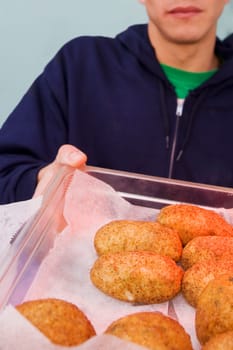 Close-up of a person holding buns in a tray