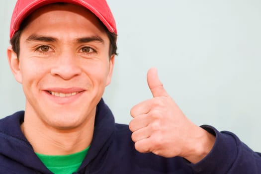 Portrait of a young man showing a thumbs up sign