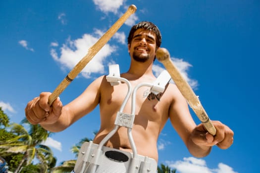 Portrait of a young man smiling and holding drumsticks