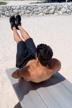 Rear view of a man exercising on the beach
