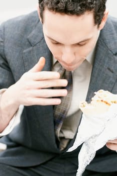 High angle view of a young man eating a sandwich