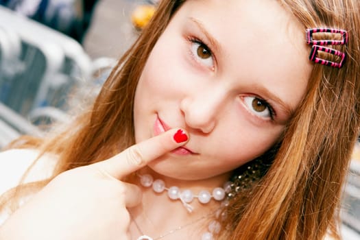 Portrait of a teenage girl with her finger on her lips
