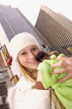 Portrait of a young woman hugging a baby monkey