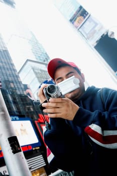 Close-up of a young man operating a home video camera