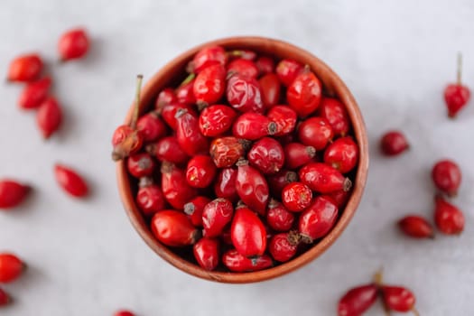 Medicinal plants and herbs. Rose hips berries on concrete background with copy space. Dried fruits for herbal teas and essential oils. Selective focus. Horizontal orientation. Flat lay.