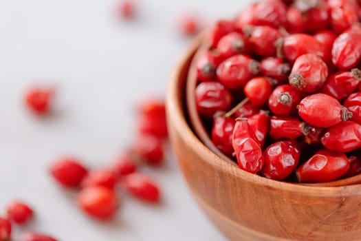 Medicinal plants and herbs. Rose hips berries on concrete background with copy space. Dried fruits for herbal teas and essential oils. Selective focus. Horizontal orientation.