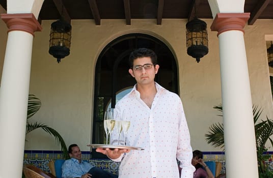 Server holding tray of champagne outdoors