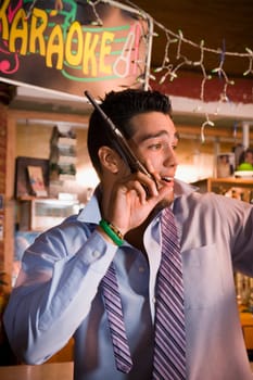 Young businessman singing at local bar, night
