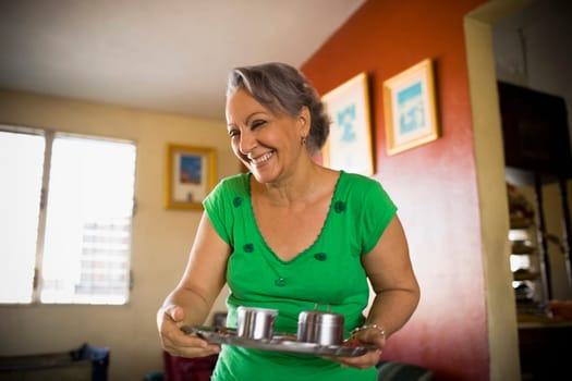 Mature woman holding a tray and smiling