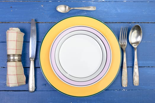 plate with silver cutlery on an old blue table