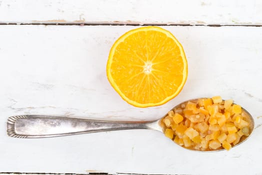 candied oranges cut into pieces on a spoon