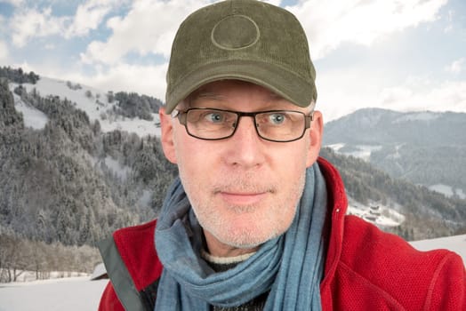 senior with cap and glasses on mountain