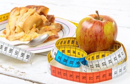 a pastry and apple with  a measuring tape