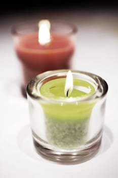 burning tea lights stand on a table