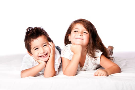 Cute happy smiling brother sister sibling family laying next to eachother, on white.