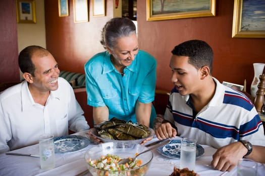 Close-up of a mature couple and their son sitting at the dining table