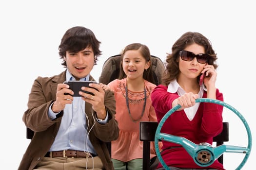 Studio portrait of distracted family in imaginary car