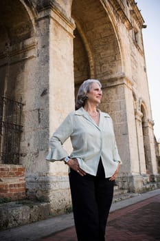Senior woman standing in front of a building and smiling, Santo Domingo, Dominican Republic