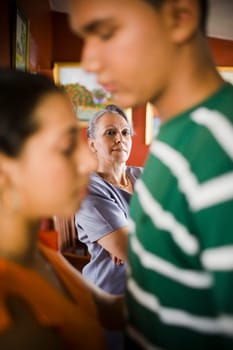 Mature woman looking at her granddaughter embracing a young man