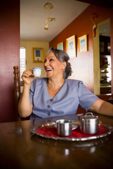 Mature woman holding a cup of tea and smiling