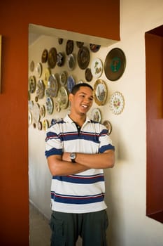 Young man standing with his arms crossed and smiling