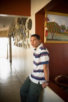 Close-up of a young man leaning against a wall and looking away