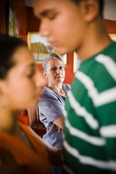 Mature woman looking at her granddaughter embracing a young man