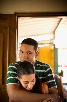 Portrait of a young man embracing a teenage girl